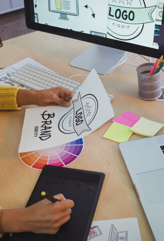 Designer creating a logo with tablet and laptop