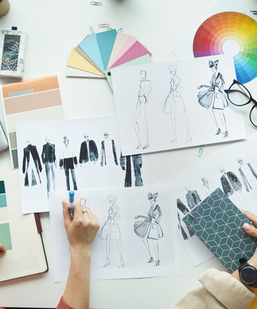 Colour wheel and fashion design sketches on a desk