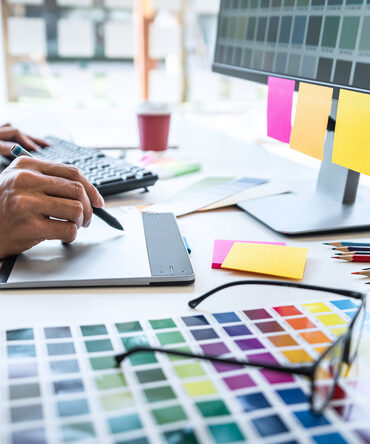 Graphic designer working on a tablet with colour palettes