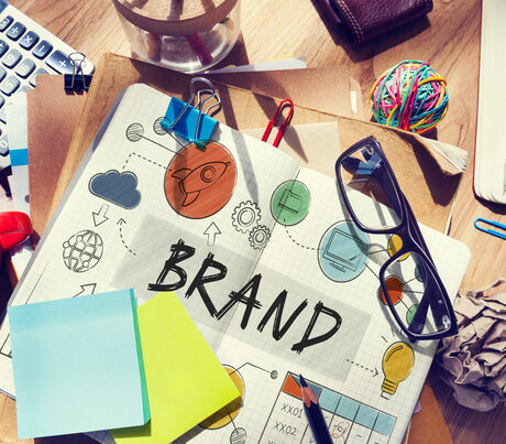 Brand sketch in a notebook on a wooden desk